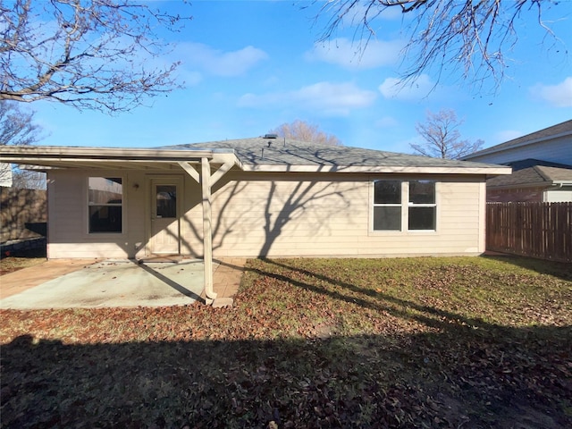 rear view of house featuring a lawn and a patio