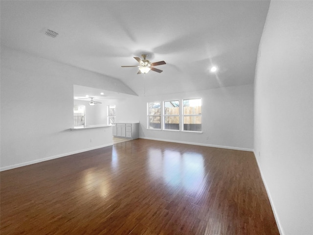 unfurnished living room with a wealth of natural light, dark wood-type flooring, and ceiling fan