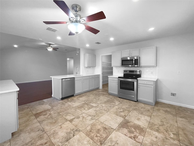 kitchen featuring sink, gray cabinets, stainless steel appliances, tasteful backsplash, and kitchen peninsula