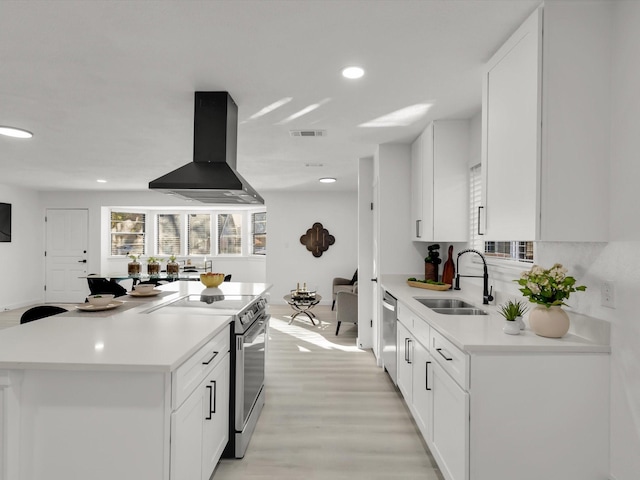 kitchen featuring white cabinetry, extractor fan, sink, and appliances with stainless steel finishes