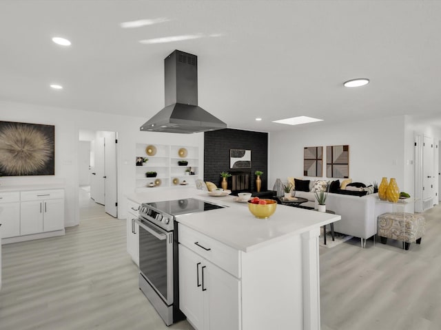 kitchen with a kitchen island, island range hood, white cabinets, electric range, and light hardwood / wood-style flooring