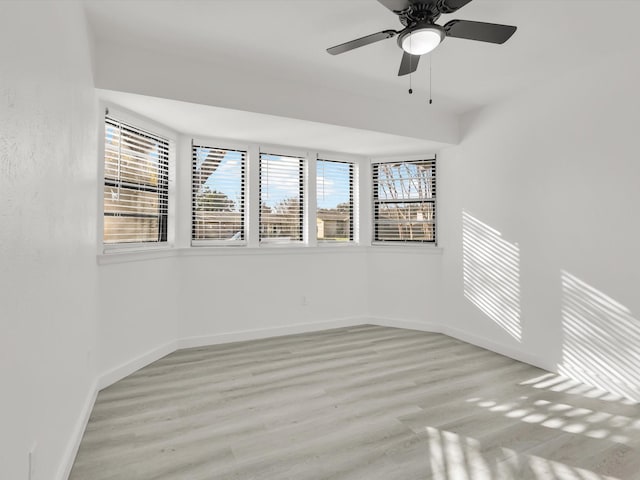 spare room with ceiling fan and light wood-type flooring