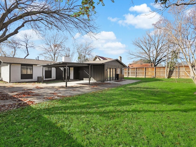 rear view of house featuring cooling unit and a yard