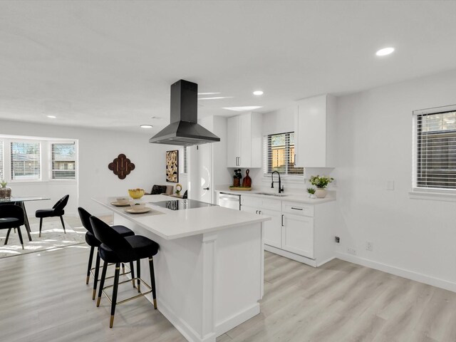 kitchen featuring white cabinetry, sink, black electric stovetop, and island exhaust hood