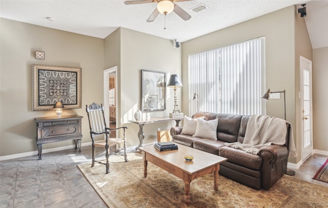 living room with a textured ceiling and ceiling fan