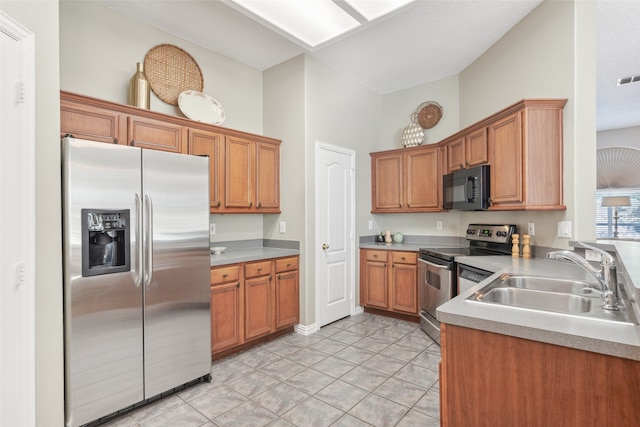 kitchen with sink, light tile patterned floors, stainless steel appliances, and a high ceiling