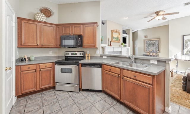 kitchen featuring sink, ceiling fan, a textured ceiling, appliances with stainless steel finishes, and light tile patterned flooring