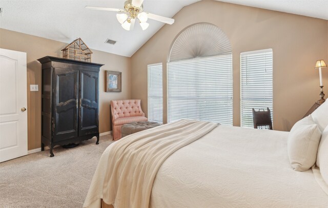 bedroom with multiple windows, ceiling fan, light colored carpet, and lofted ceiling