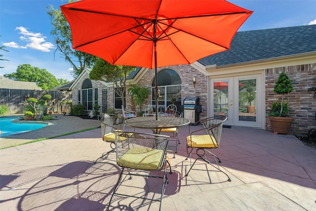 view of patio / terrace featuring area for grilling, a fenced in pool, and french doors