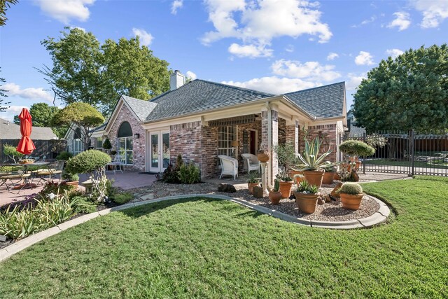 rear view of house featuring a patio and a lawn