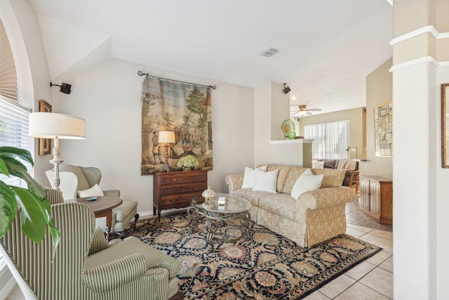 living room with ceiling fan, light tile patterned floors, and lofted ceiling