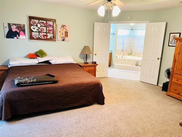 bedroom with ceiling fan, ensuite bath, and light carpet