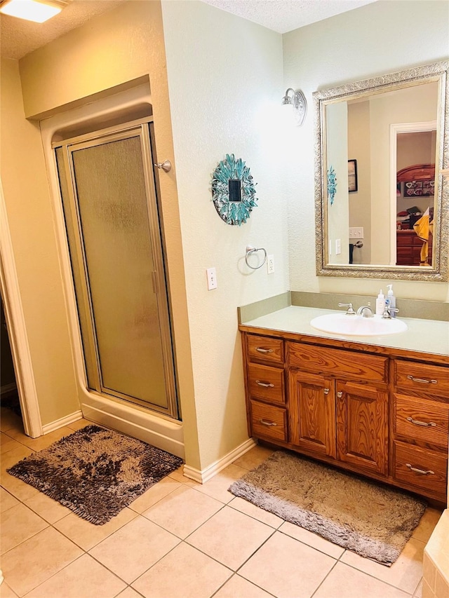 bathroom with vanity, tile patterned floors, a textured ceiling, and walk in shower