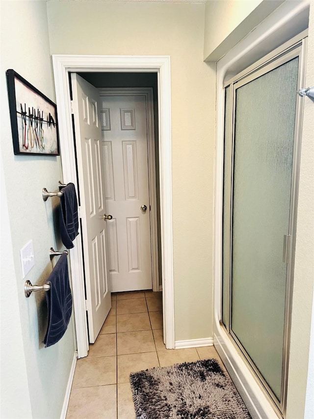 bathroom with tile patterned flooring and a shower with shower door