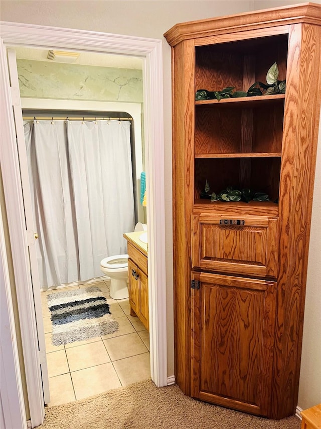 bathroom featuring tile patterned flooring, vanity, and toilet