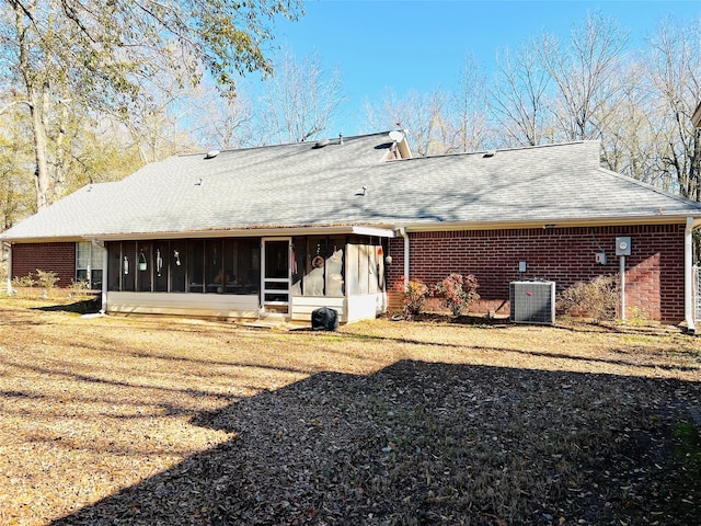 rear view of house featuring central AC unit and a sunroom