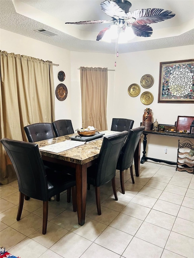 dining room with light tile patterned flooring, ceiling fan, and a textured ceiling