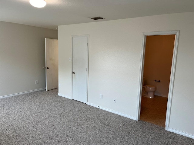 unfurnished bedroom featuring carpet flooring and connected bathroom