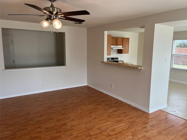 unfurnished living room featuring ceiling fan and wood-type flooring