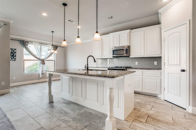 kitchen with sink, an island with sink, white cabinets, and a breakfast bar