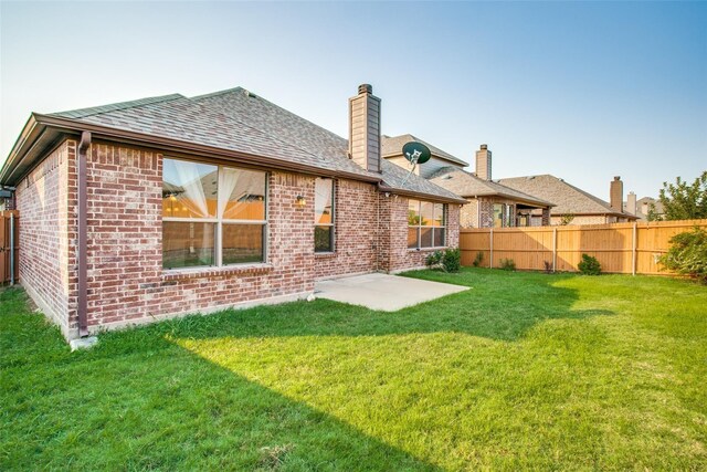 back of house with a yard and a patio area