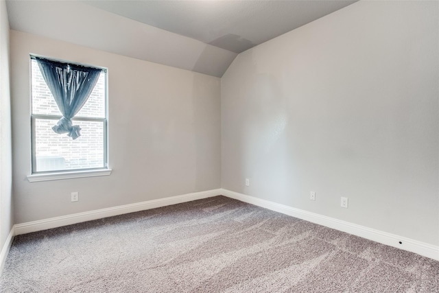 spare room with carpet and lofted ceiling