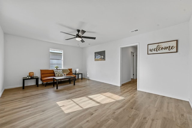 living area with light wood finished floors, ceiling fan, visible vents, and baseboards