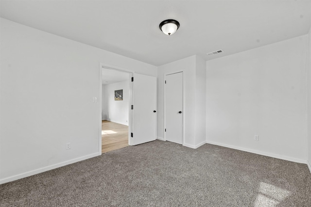 carpeted empty room with baseboards and visible vents