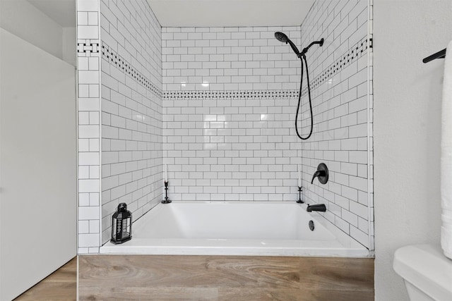 bathroom featuring tub / shower combination and toilet