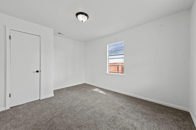 carpeted empty room with visible vents and baseboards