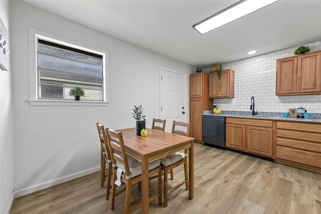 kitchen with light wood-type flooring, dishwashing machine, tasteful backsplash, and brown cabinets