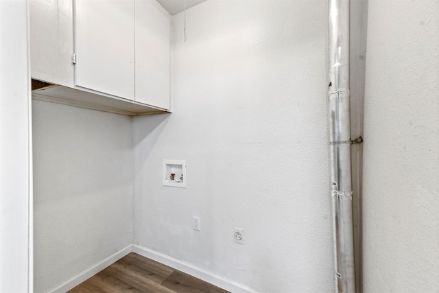 laundry area featuring hookup for a washing machine, hookup for an electric dryer, dark wood-type flooring, baseboards, and cabinet space