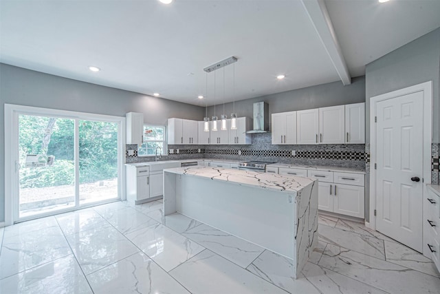 kitchen featuring stainless steel range with electric stovetop, white cabinetry, a kitchen island, decorative light fixtures, and wall chimney exhaust hood