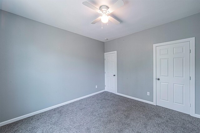 carpeted spare room featuring ceiling fan