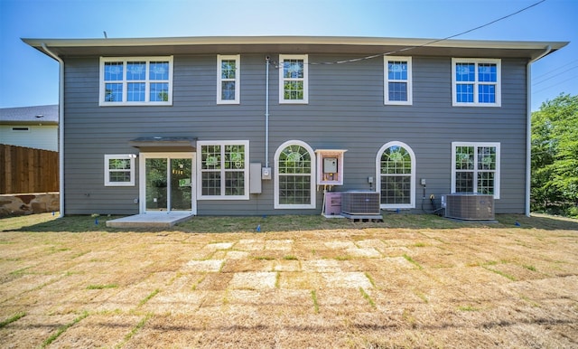 rear view of property with a yard and central AC