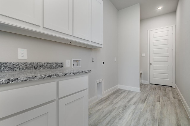 washroom with hookup for an electric dryer, cabinets, hookup for a washing machine, and light hardwood / wood-style flooring