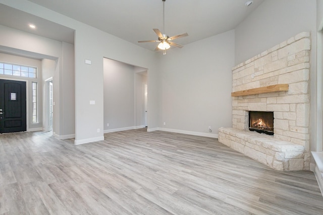 unfurnished living room with ceiling fan, light wood-type flooring, and a fireplace