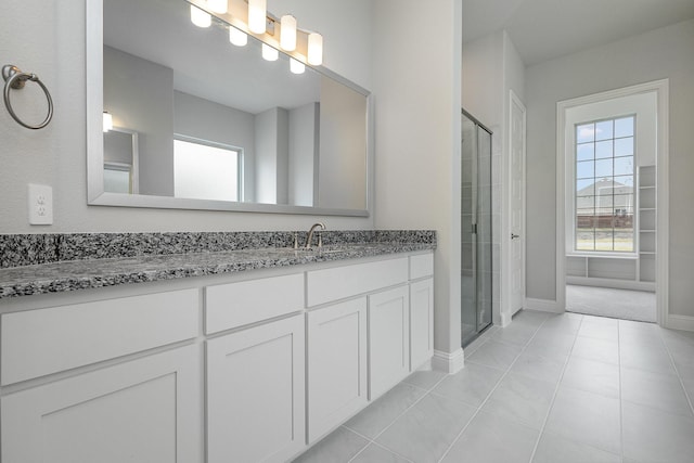 bathroom featuring tile patterned flooring, vanity, and walk in shower