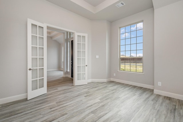 spare room with french doors and light hardwood / wood-style flooring