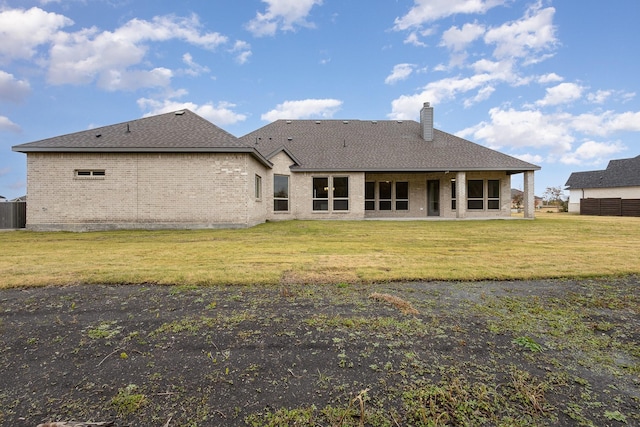 back of property featuring a lawn