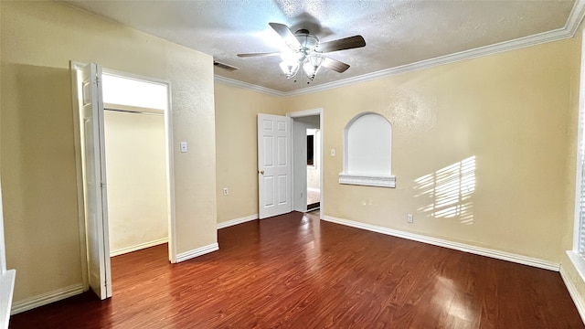 empty room with a textured ceiling, ceiling fan, dark hardwood / wood-style floors, and ornamental molding