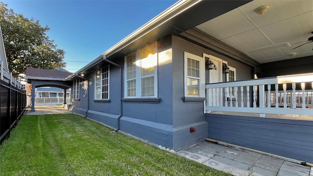 view of side of home featuring a porch and a yard