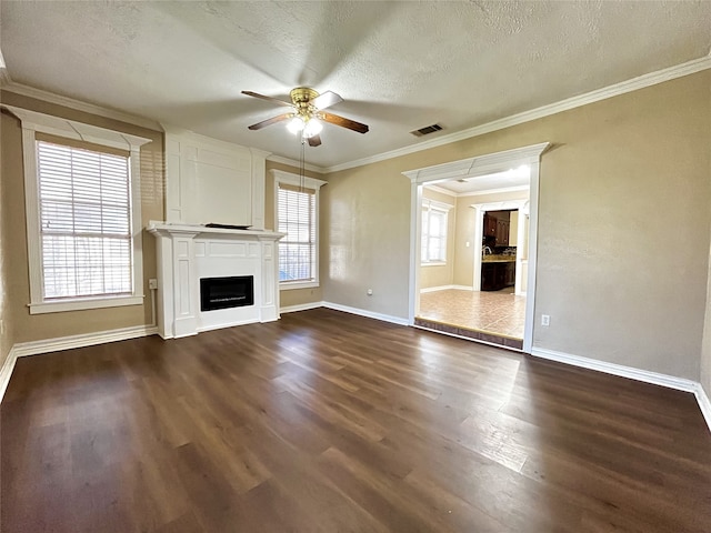 unfurnished living room with dark hardwood / wood-style floors, ceiling fan, crown molding, and a textured ceiling