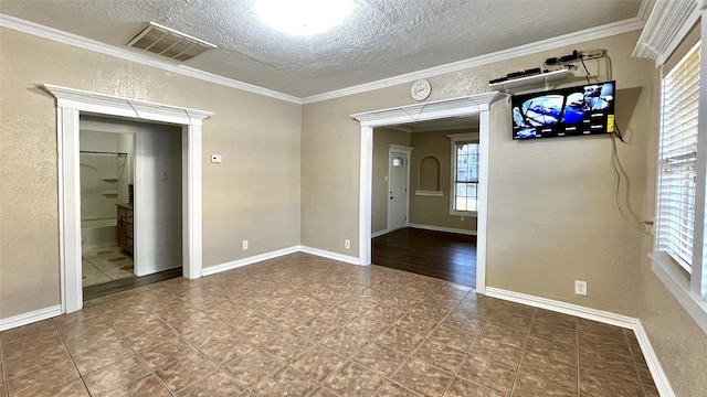 unfurnished room featuring a textured ceiling and ornamental molding