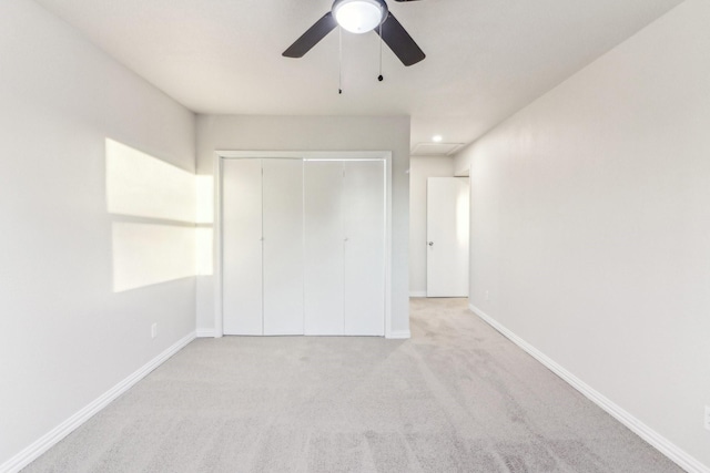 unfurnished bedroom with ceiling fan, a closet, and light colored carpet