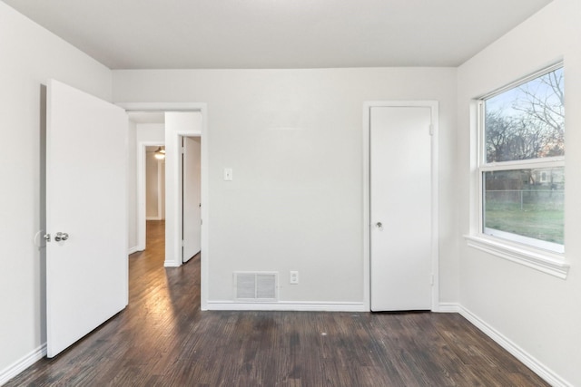 unfurnished bedroom with dark hardwood / wood-style floors