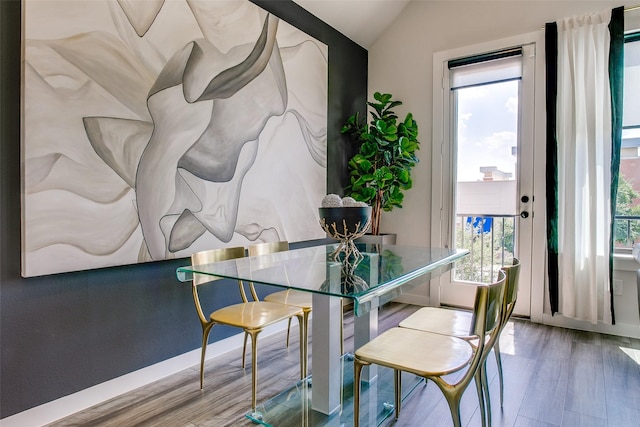 dining area with lofted ceiling and wood-type flooring