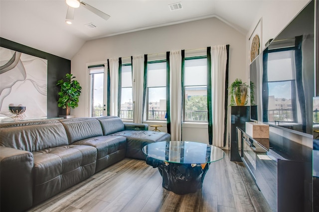 living room featuring light hardwood / wood-style floors, vaulted ceiling, and ceiling fan