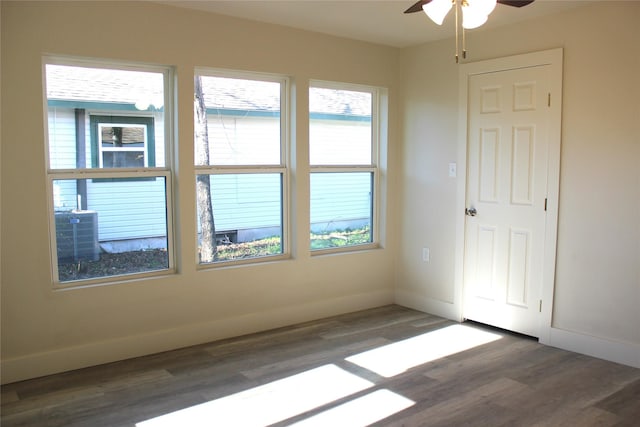 empty room featuring dark hardwood / wood-style floors, plenty of natural light, and ceiling fan