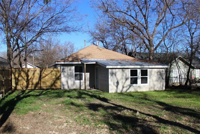 rear view of house featuring a yard